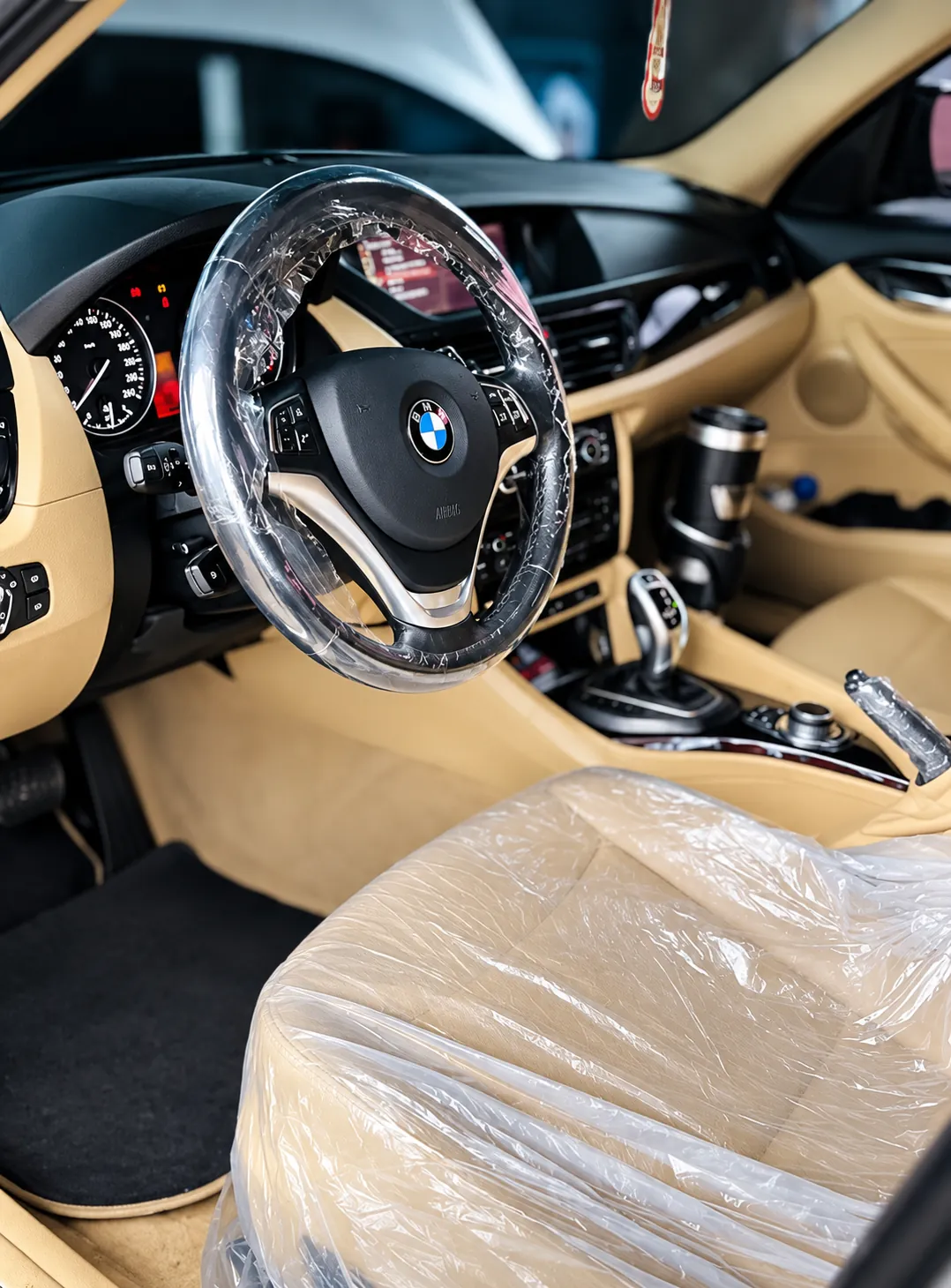 Interior de um veículo com capa plástica de proteção no volante, no banco e na alavanca de câmbio durante o serviço
